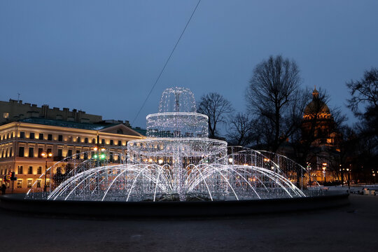 christmas new year street decoration fountain of lights in the night in Saint Petersburg, Russia with Staint Isaac's cathedral on the background