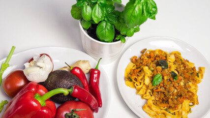 pasta Bolognese with fresh vegetables and basil