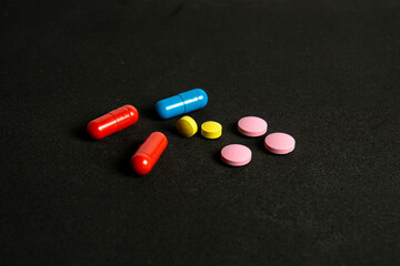 Colorful pills over dark background