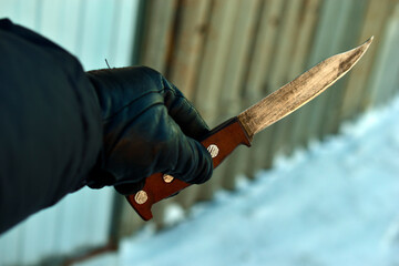 An iron knife in the hand of a man in winter