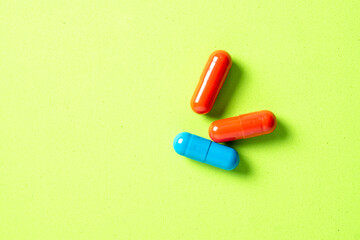 Colored pills and tablets on green background. Close up. Medical treatment concept.