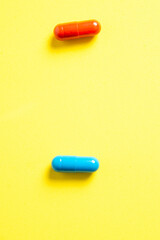 Heap of pills on yellow background