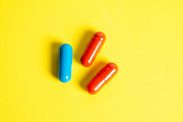 Heap of pills on yellow background