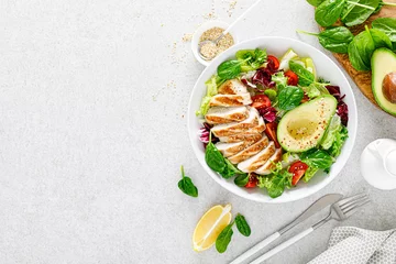 Poster Grilled chicken meat and fresh vegetable salad of tomato, avocado, lettuce and spinach. Healthy and detox food concept. Ketogenic diet. Buddha bowl dish on white background, top view © Sea Wave