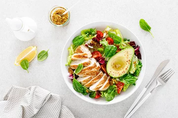 Rollo Grilled chicken meat and fresh vegetable salad of tomato, avocado, lettuce and spinach. Healthy and detox food concept. Ketogenic diet. Buddha bowl dish on white background, top view © Sea Wave