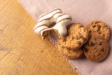 Cookies and pão de mel arranged on a rustic wooden surface with fabric, selective focus..