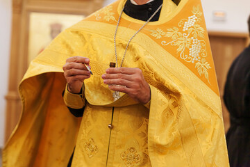 Orthodox Church. Christianity. Priest hands holding oil for anointing at baptismin on traditional Orthodox Church background. Religion faith pray symbol. Orthodox baptism celebration.