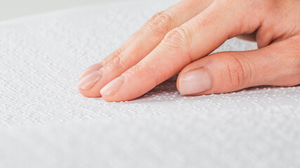 A woman reads a book written in Braille.