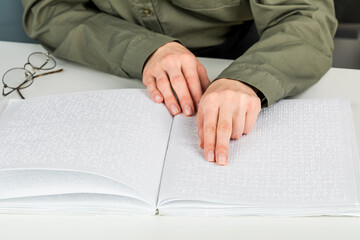 A woman reads a book written in Braille.