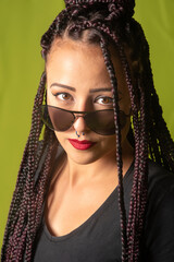 Beautiful girl with pigtails in her hair and sunglasses, colorful background, selective focus.