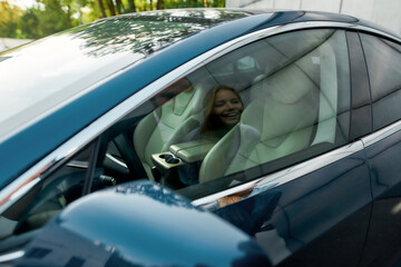 Smiling young caucasian couple reflecting in car window