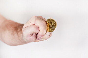 Hand holds a coin depicting a bitcoin symbol depicting a fig