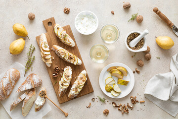 Open sandwiches with ricotta cheese, fresh pears, walnuts and honey on breakfast table, overhead view