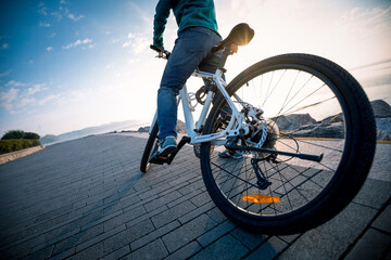 Cyclist riding bike in the sunrise coast path