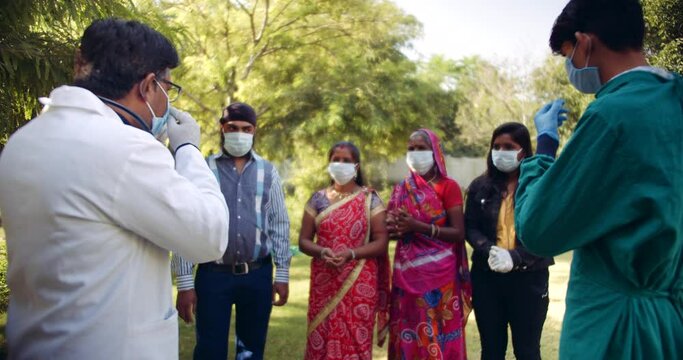Group of people of different religious groups in India- Sikhism, Hinduism, Islam, Muslim listen intently with attention of instructs of hygiene washing hands social distance from doctor nurse  