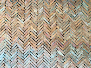 The wall is made of orange brick used for zigzag bricks.