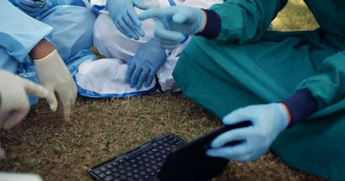 Slow-motion portrait group of healthcare workers essential emergency staff talk discuss share bond chat gossip using laptop tablet computer digital technology device in front lawns outdoors