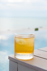 Glass with whiskey on the nature background with empty space to text.