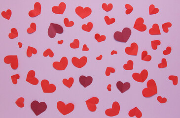 Lots of little red hearts on a pink background. Background for decor. Top view