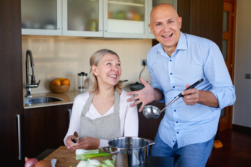 Mom and adult son in the kitchen preparing food