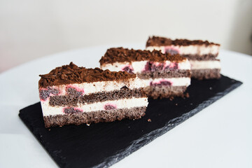 a slice of chocolate chip cake on a black tray. High quality photo