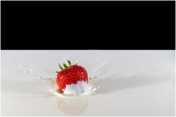 Strawberry splashing in white liquid