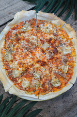 Top view Hawaiian Pizza in a white plate on a wooden table.
