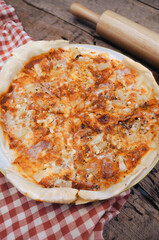 Hawaiian Pizza in a white plate on a wooden table.