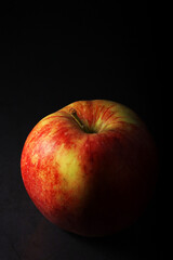 An apple against black background