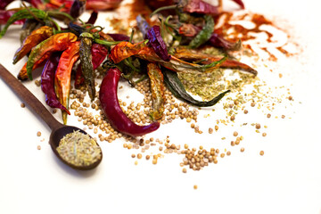 Dried red peppers and spoon with rosemary. Different spices. On a white background.