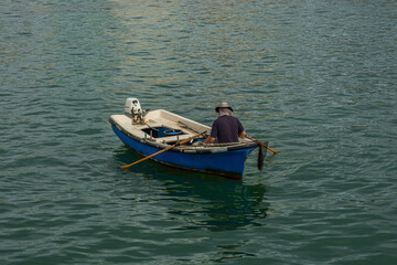 Fisherman in his small boat fishing in the sea