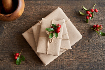 Fresh wintergreen twigs on Christmas presents wrapped in ecological recycled paper