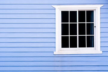 White frame vintage window on blue wooden wall.