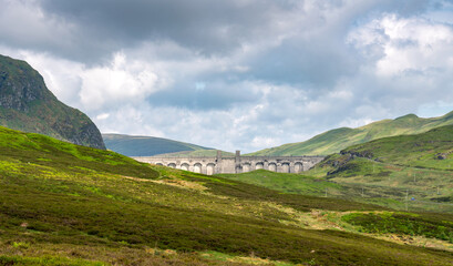 The dam wall and towers of Lochan na Lairige reservoir near Loch Tay in the Scottish Highlands, UK.