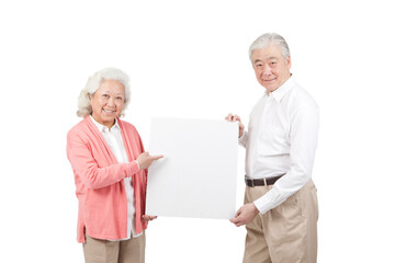 An old senior couple holding white board 