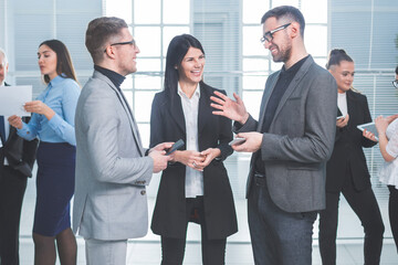 group of young employees standing in the office lobby during a work break