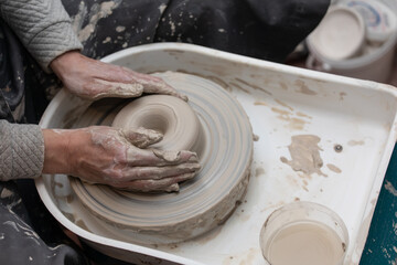 Hands working on pottery wheel
