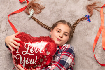 cute smiling girl holding red heart shaped balloon