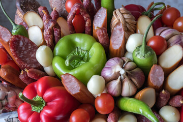 A set of products made up of various sausages, cheeses, peppers and garlic