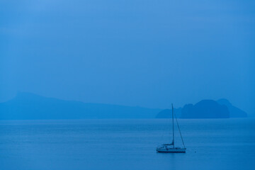 Fototapeta premium Anchored yacht in the Andaman Sea off the coast of Khao Yao, Phang Nga, Thailand at blue hour.