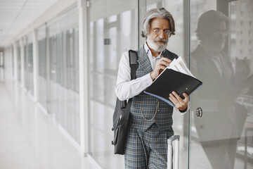 Fototapeta premium Close up portrait of grinning old-fashioned man. Elegant man at the office. Senior with a documents.
