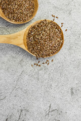 Food background, oilseed, flax seeds in two wooden spoons, food supplement for digestion, source of...