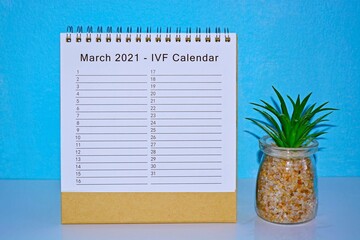 Fototapeta na wymiar March 2021 IVF calendar with blue background and potted plant