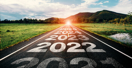 2022-2025 written on highway road in the middle of empty asphalt road at golden sunset and...