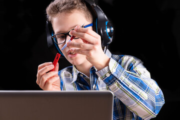 Person at laptop replaces empty ink cartridge in fountain pen