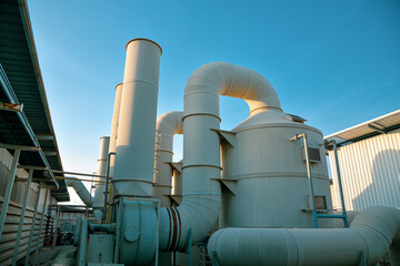Industrial plant for filtering air polluted ponds with tanks, and water tanks on blue sky background.