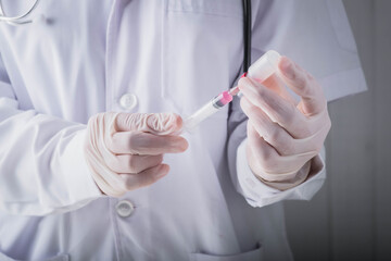 Coronavirus vaccine and development and creation COVID-19 vaccine concept.Doctor hand in gloves hold medical vaccine bottles dose and syringe ready to treat the patient.
