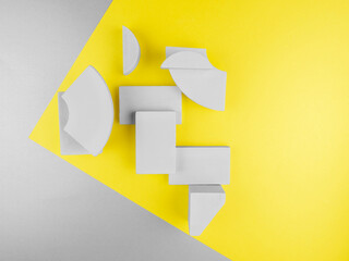 Close up abstract grey wooden geometric 3D figures: rectangles, segments of circle, arc on two-tone yellow gray paper backdrop at corner.2021 color concept with copy space.Design layout for text,card