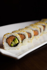 A sushi roll on a white plate. California sushi roll