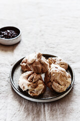 Homemade sweet chocolate meringue cookies on plate over greige linen tablecloth. Delicious and light holiday dessert